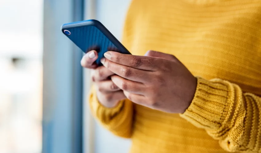 mãos de mulher segura o celular e aprende a realizar o bloqueio seguro para proteger o seu celular 