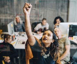 Mulher que trabalha em startup apresenta para o seu time soluções para melhorar a vida da comunidade local