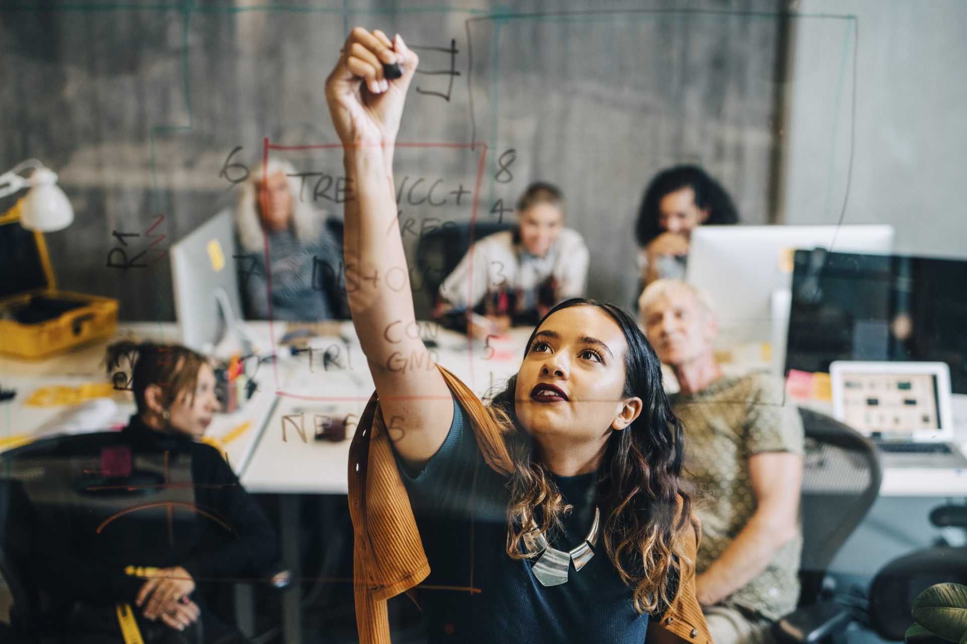 Mulher que trabalha em startup apresenta para o seu time soluções para melhorar a vida da comunidade local