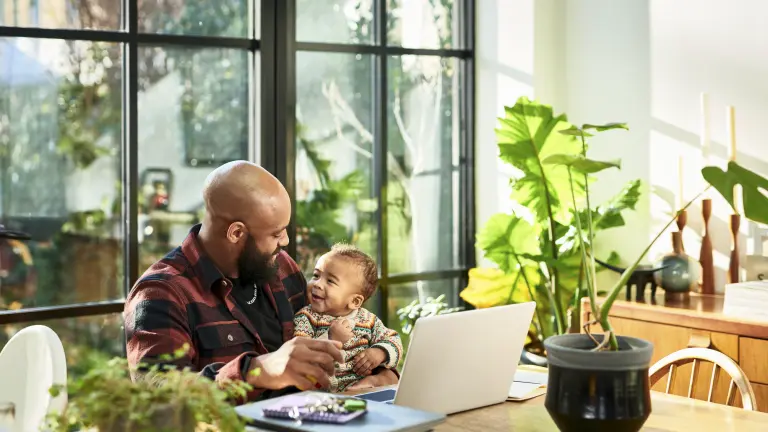 Por causa do trabalho remoto, muitos pais têm a chance de ficar mais próximos dos filhos, como é o caso deste homem, que está brincando com o seu bebê 