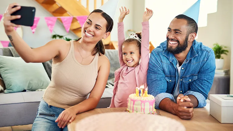 Mulher tira foto com a sua família do aniversário da filha para compartilhar com outros parentes e nas redes sociais 