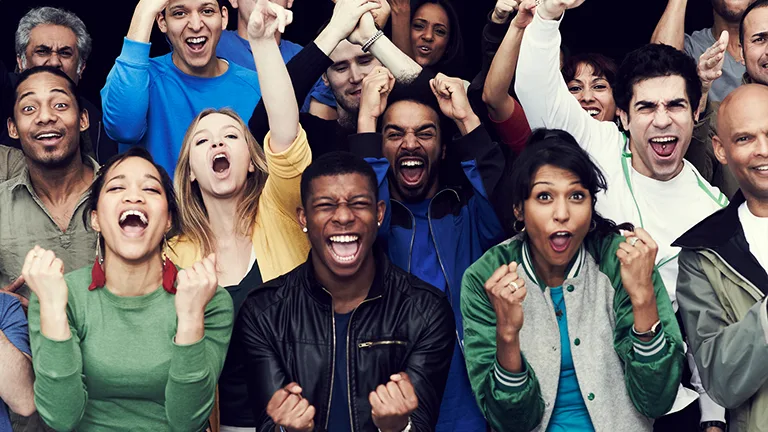 Muitas pessoas, de todas as cores, gêneros e idade, comemoram juntas de forma alegre 