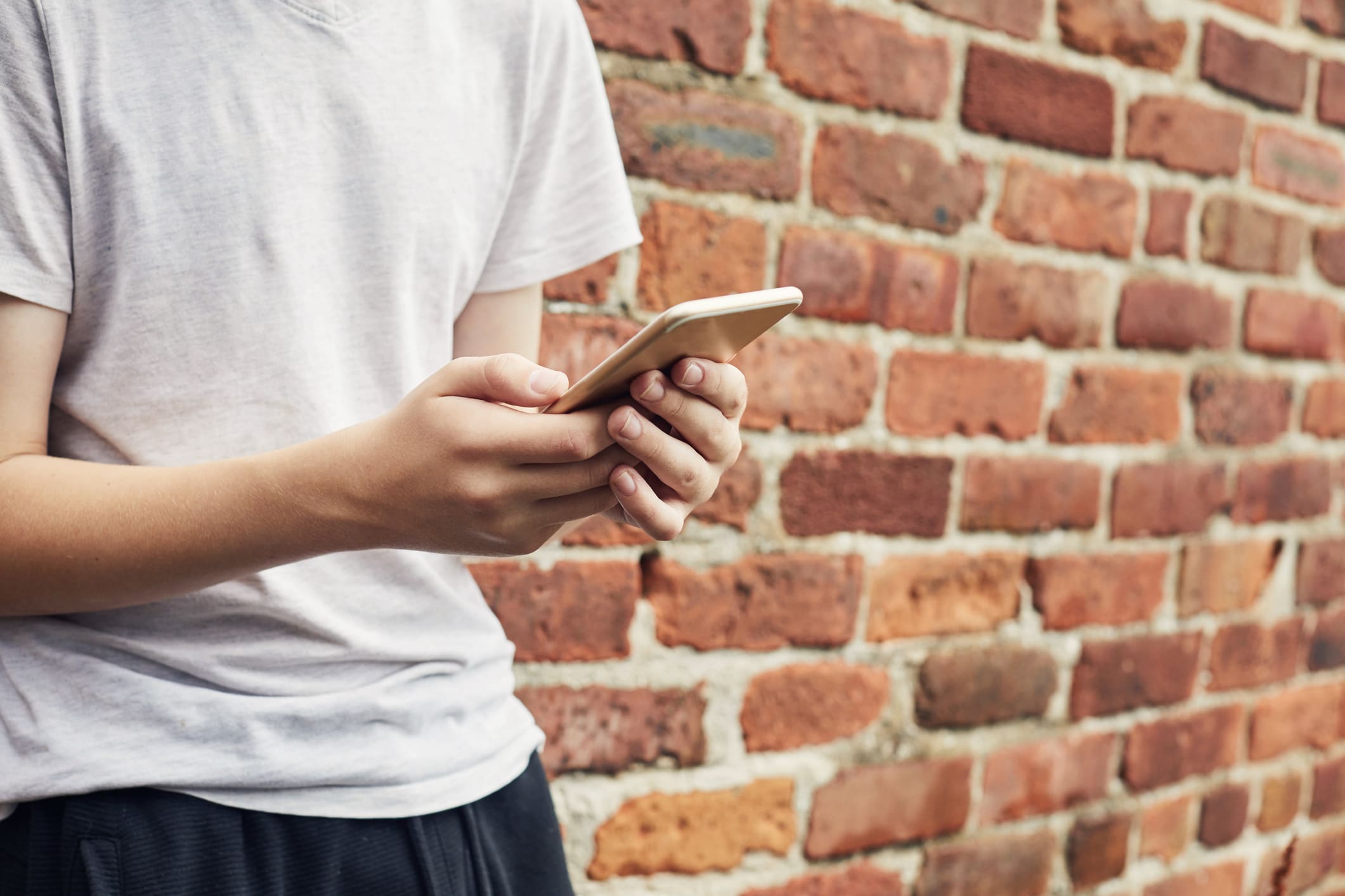 Jovem usa celular escondido. Os jovens têm propensão a aprenderem com a cultura incel, por isso, é importante guiá-los para uma educação mais inclusiva