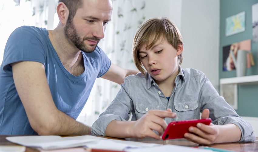 Pai checa com o filho o rendimento dele escolar no app sala do futuro