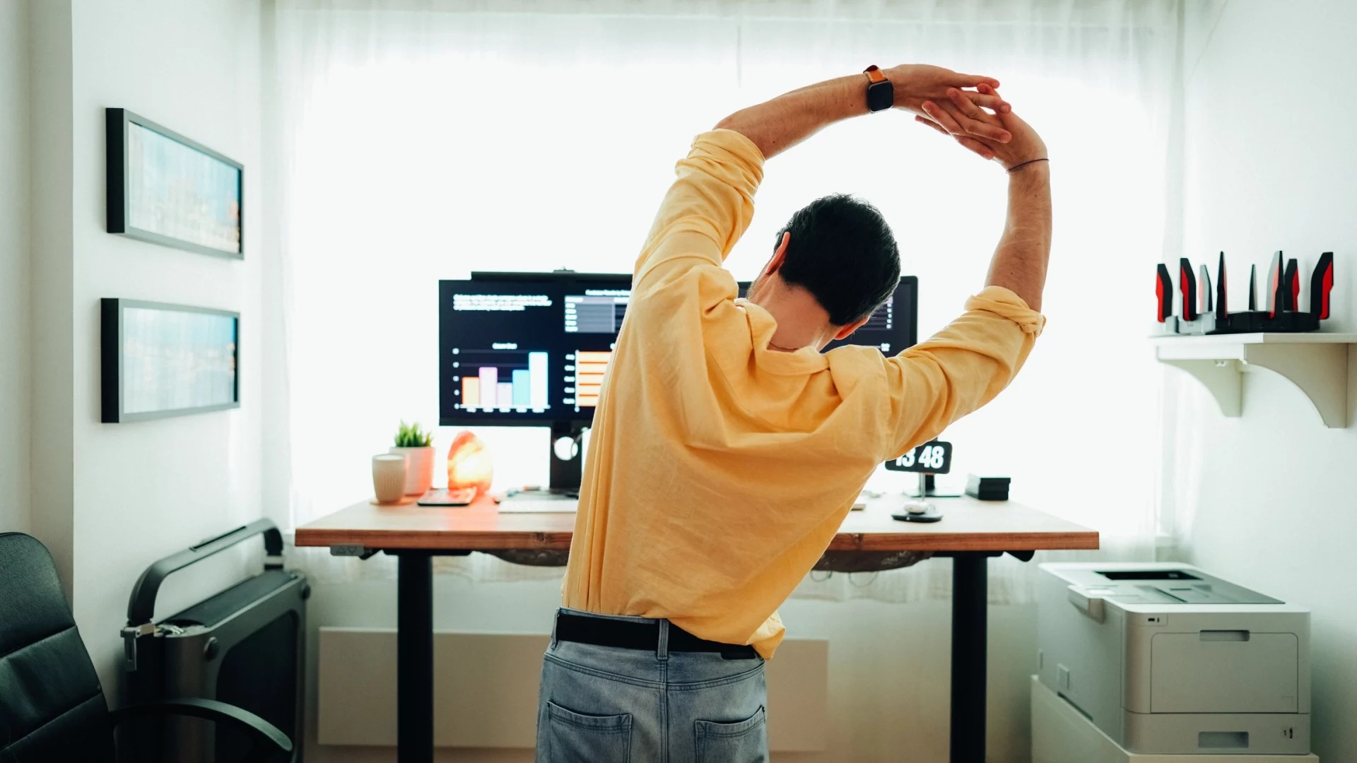 Homem faz alongamento na frente do seu local de trabalho para ter mais ergonomia na rotina