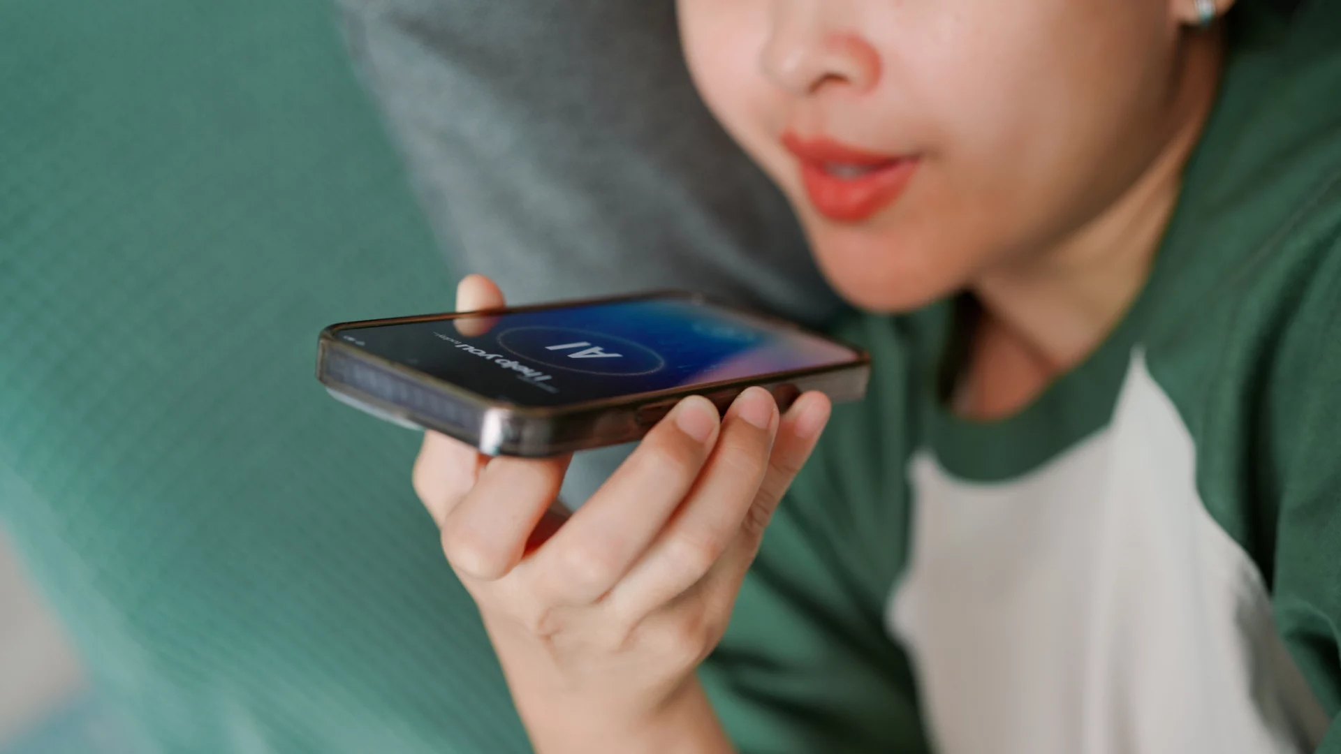 Close de uma pessoa falando ao celular com a interface de IA ativada na tela, utilizando a lei do esforço mínimo para realizar tarefas por voz.